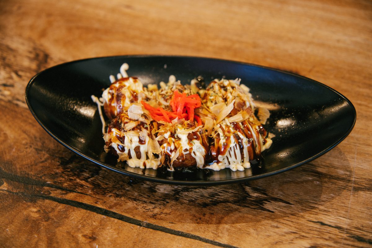 Takoyaki topped with sauce and bonito flakes